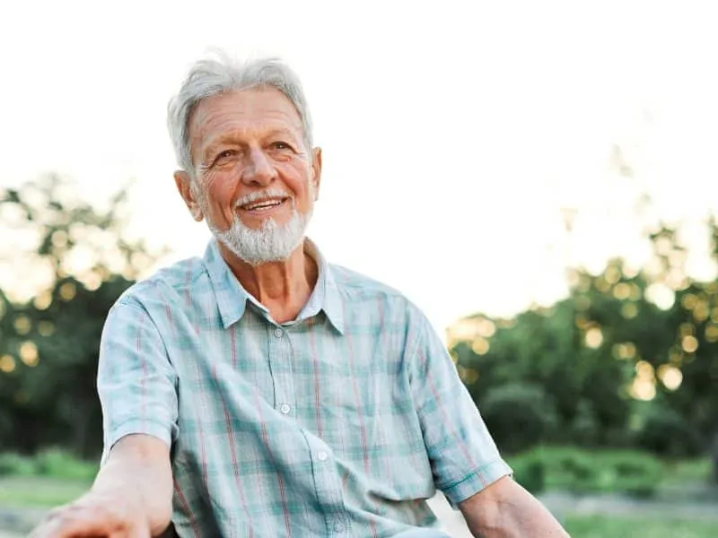 old man outside smiling