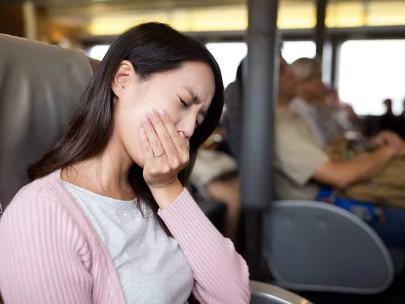 Woman feeling unwell and sitting on the ferry