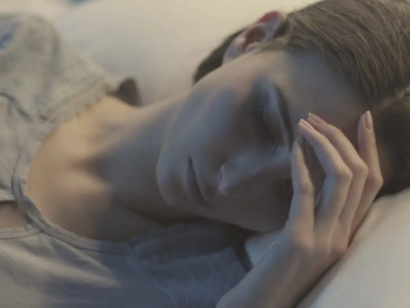 Young female patient lying in a hospital bed at night and sleeping, healthcare concept