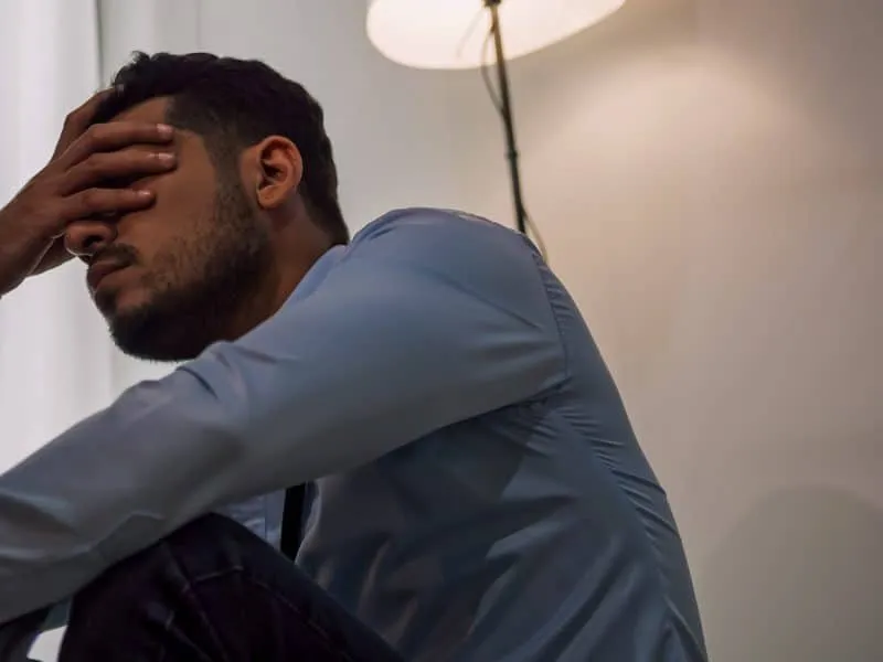 A businessman sitting on the floor depressed and stressed with problems in his life.