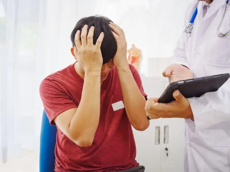 A man consults a doctor in a hospital for male urinary tract infection.doctor advises on symptoms