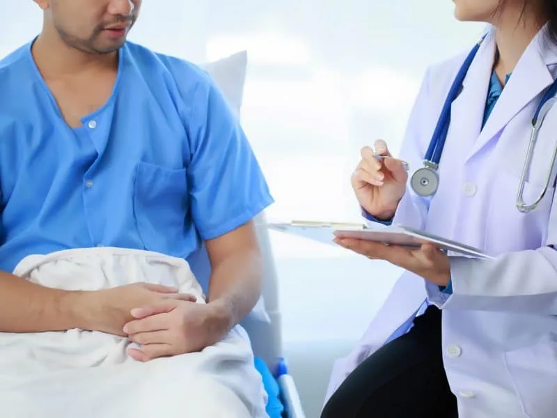 Doctor talking with patient in hospital, The doctor is explaining information about various diseases and treatment methods in detail for the patient to understand before treatment.