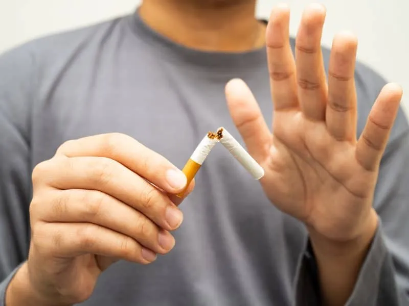 Quit smoking, Asian teenage man breaking destroy cigarette in hand.