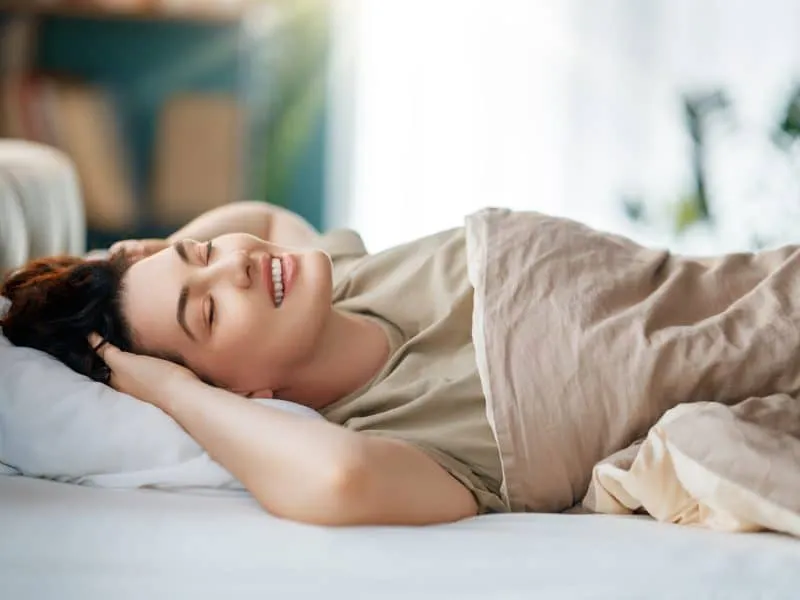 A beautiful young woman is sleeping in the bedroom at home.