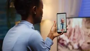 African famele having conference call with her doctor about illness treatment sitting in living room late at night. Black patient in a video call with medic discussing health problems of woman