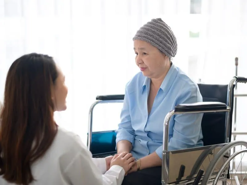 Cancer patient woman wearing head scarf after chemotherapy consulting and visiting doctor in hospital.