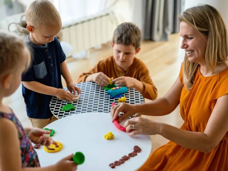 Family activities in the kids room. Woman and children playing together. Fun, education concept.