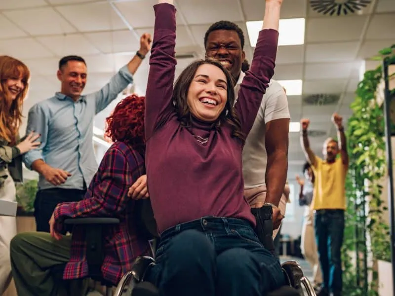 woman on wheelchair cheering happily