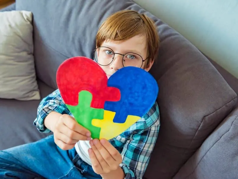 Young boy holding puzzle jigsaw, child mental health concept, world autism awareness day, autism spectrum disorder awareness concept