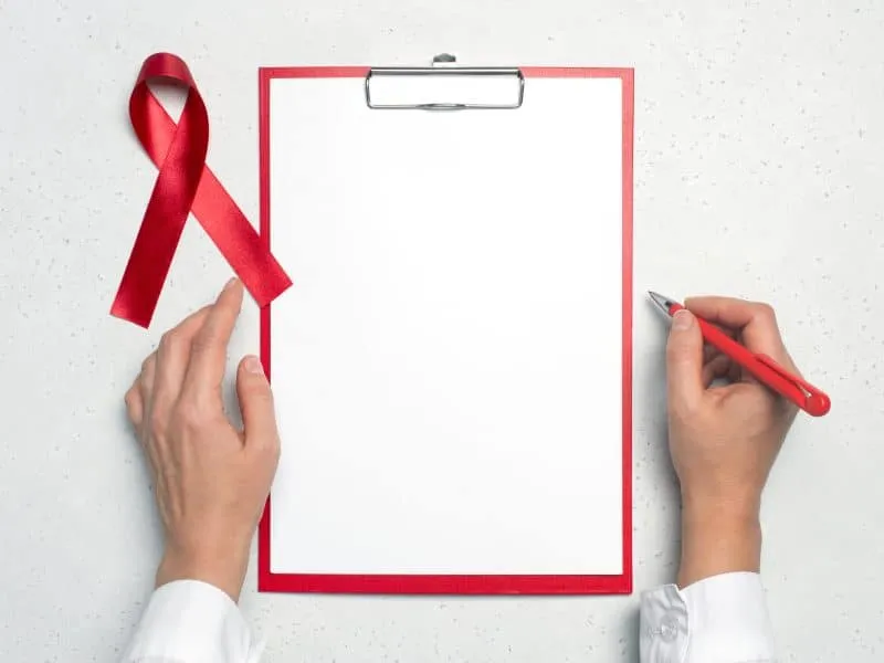 AIDS red ribbon on the doctors desk, white background