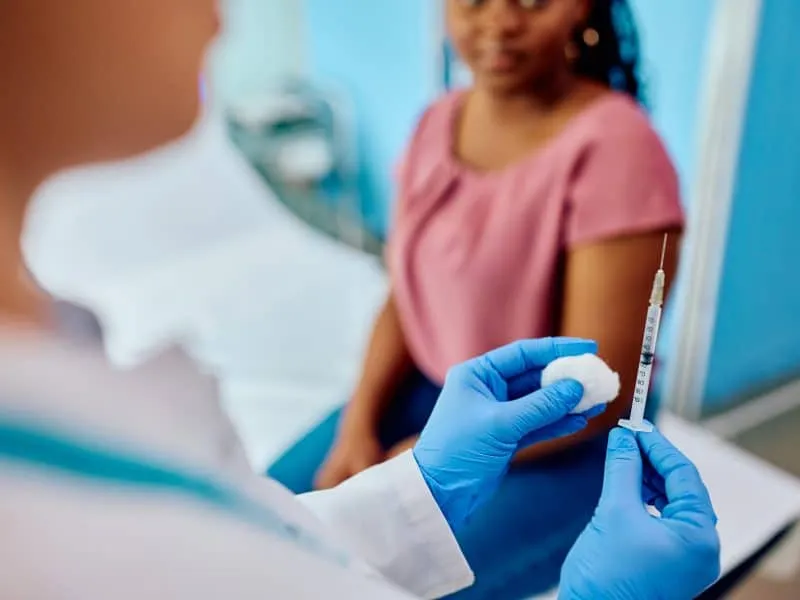Close up of female doctor preparing syringe for patient's vaccination in the hospital.