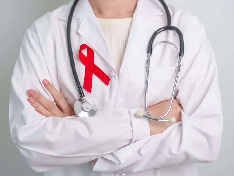 Doctor with Red Ribbon for December World Aids Day, acquired immune deficiency syndrome, multiple myeloma Cancer Awareness month and National Red ribbon week. Healthcare and world cancer day concept