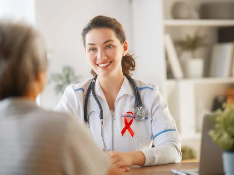 Colour ribbon for concept of illness awareness. Female patient listening to doctor in medical office. Raising knowledge on people living with disease.