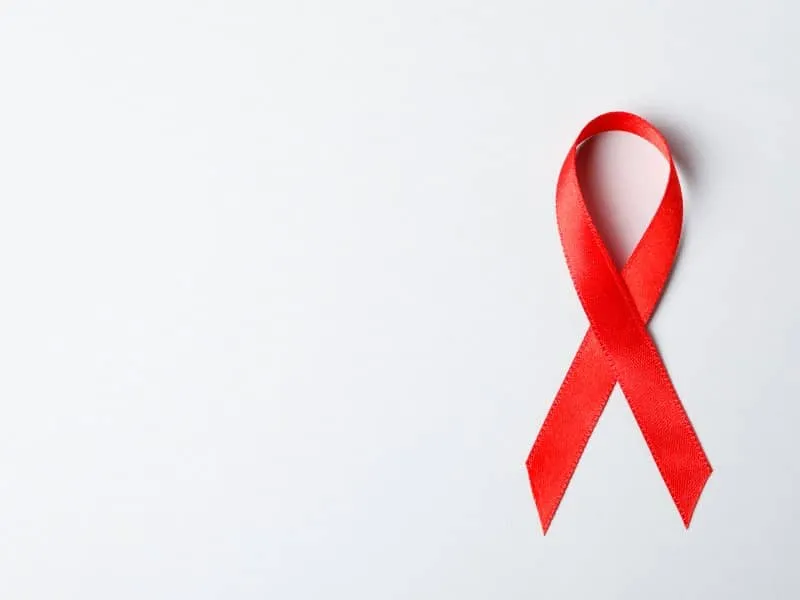 Red awareness ribbon on red background, space for text
