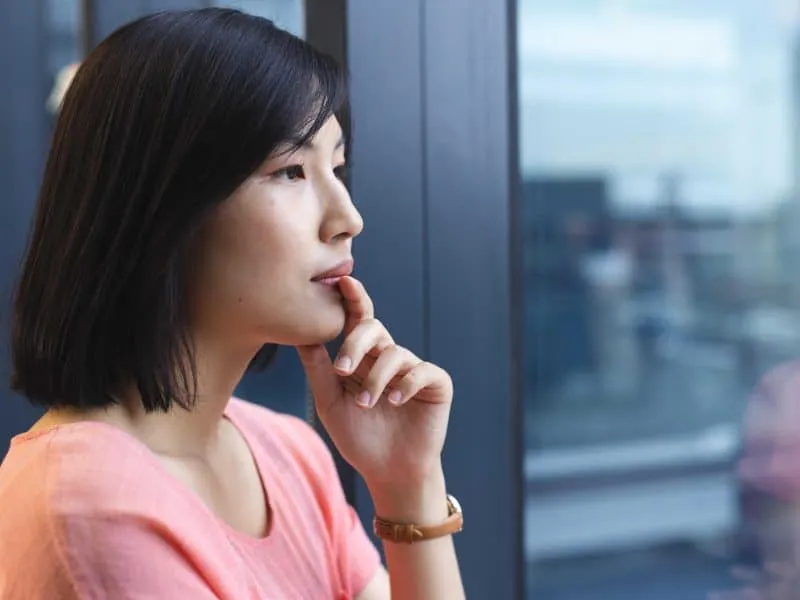 woman standing near window and looking out