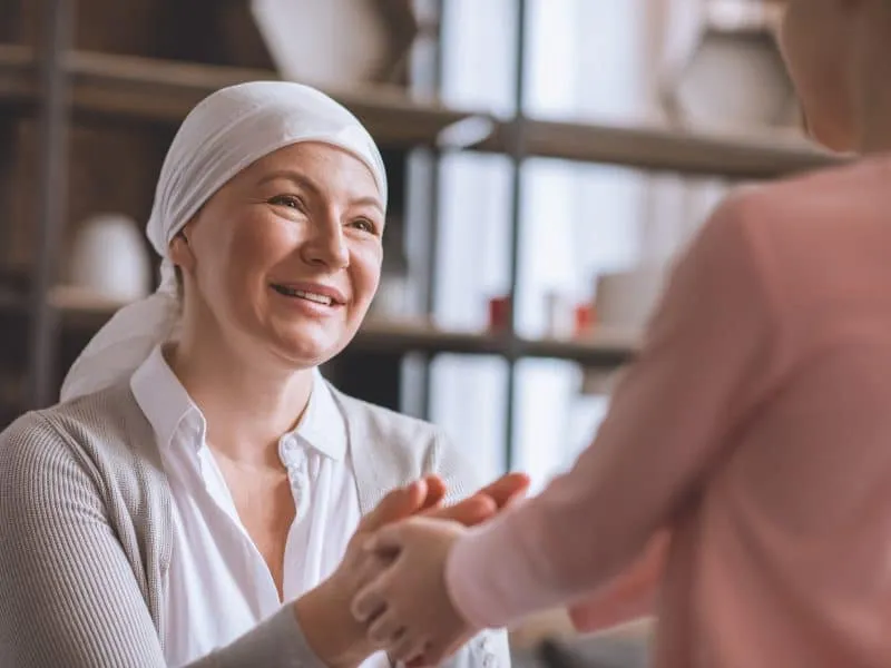 woman with white cloth on head talking to a kid