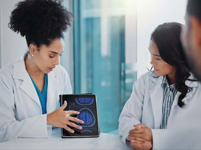Healthcare, surgeon on tablet and doctor with group in discussion, talking and report about medical.