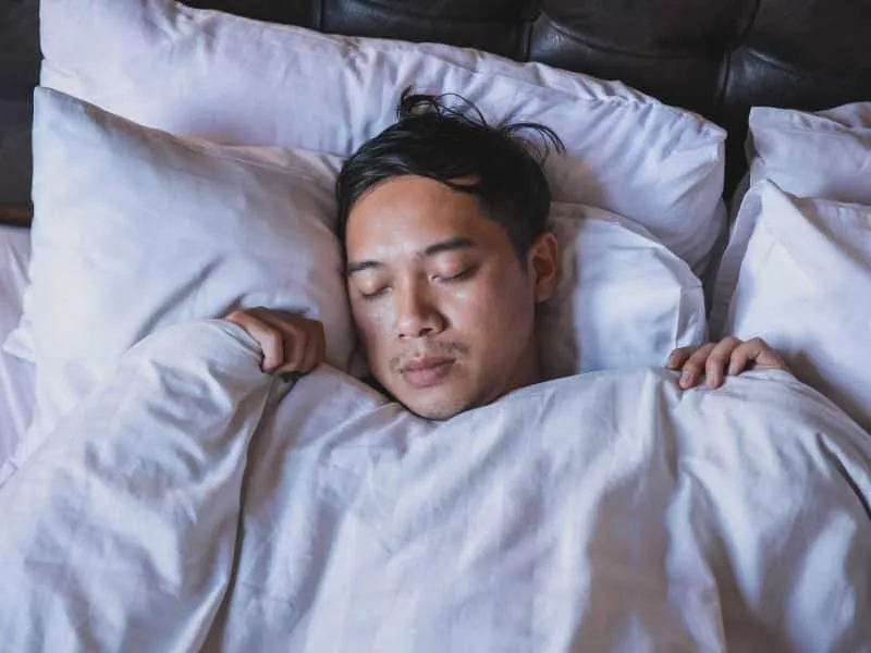 man sleeping on bed