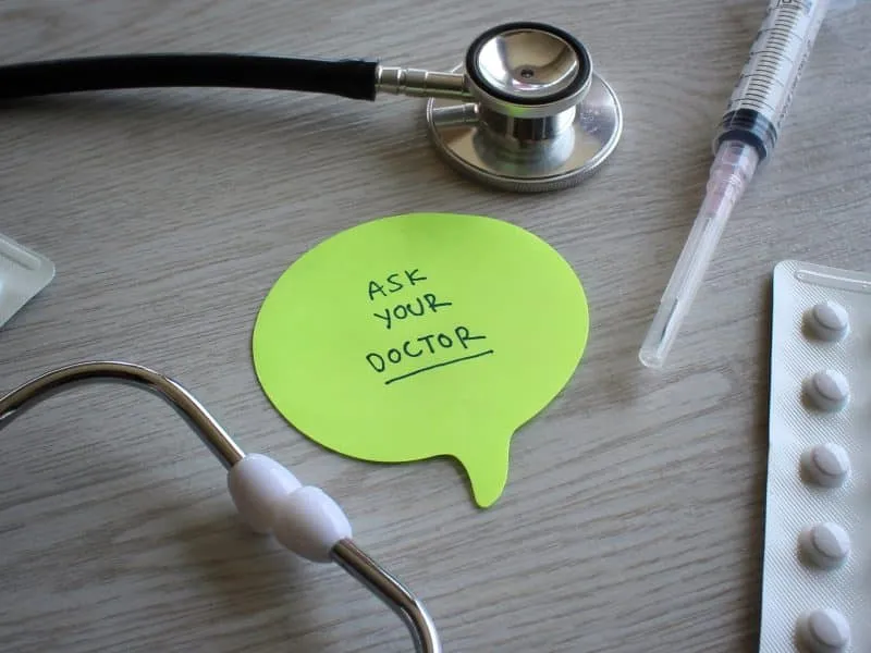 Medical concept. Stethoscope, syringe, tablets and speech bubble with text ASK YOUR DOCTOR.