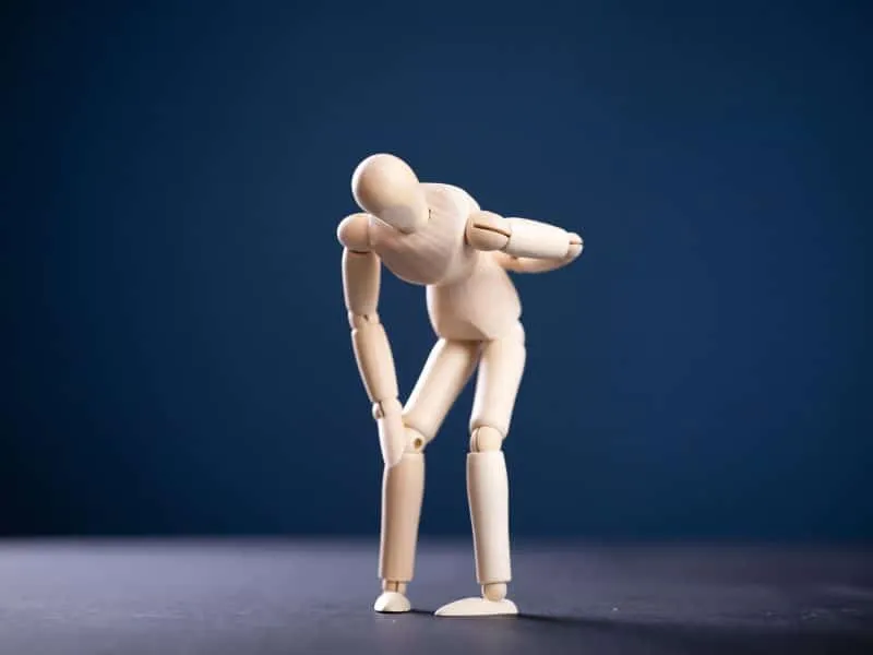 Wooden man with back pain. Medical concept.