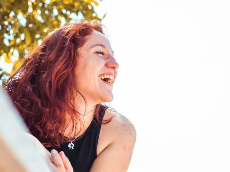 redhead girl lauging in the park