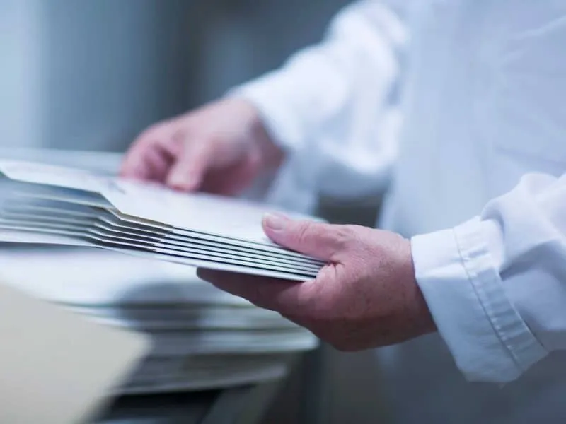 Worker Holding Cardboard Packaging in Pharmaceutic