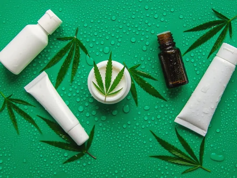 Cosmetics with cannabis extract on a wet background. Selective focus. Spa.