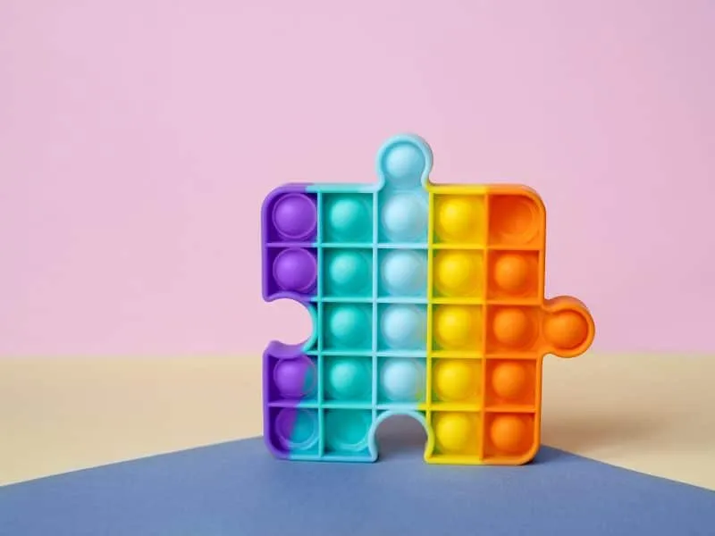 New popular silicone colorful anti-stress popit toy for baby on the background with geometric shapes. simple dimple. Pop it toy