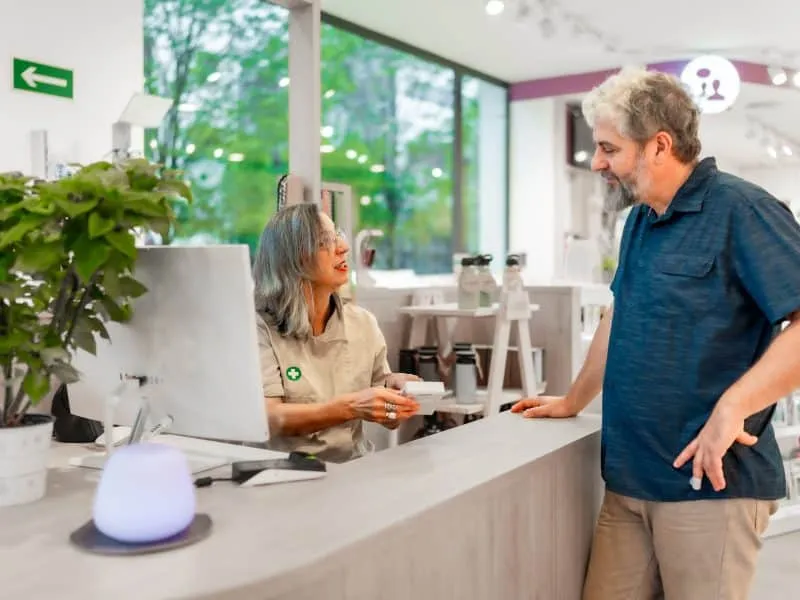 Female mature pharmacist attending to a customer in a store