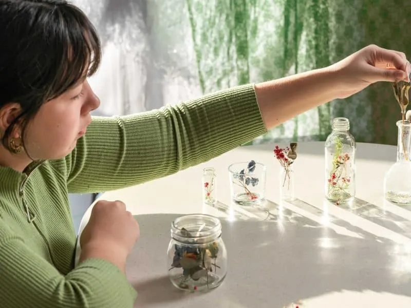 girl sitting on a table and collecting florals