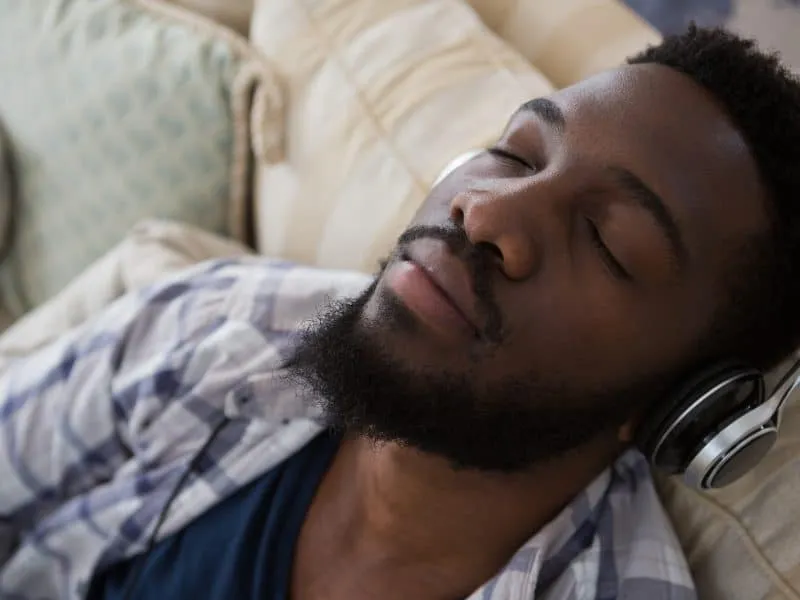 Man sleeping while listening to music at home