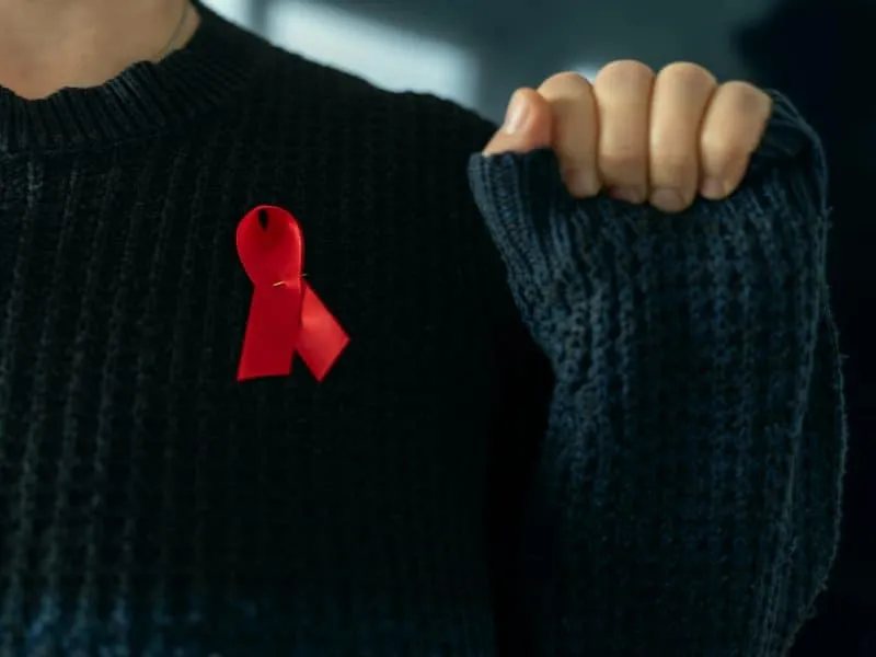Red AIDS Awareness Ribbon on Womans Chest