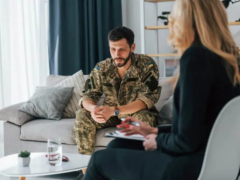 Soldier have therapy session with psychologist indoors.