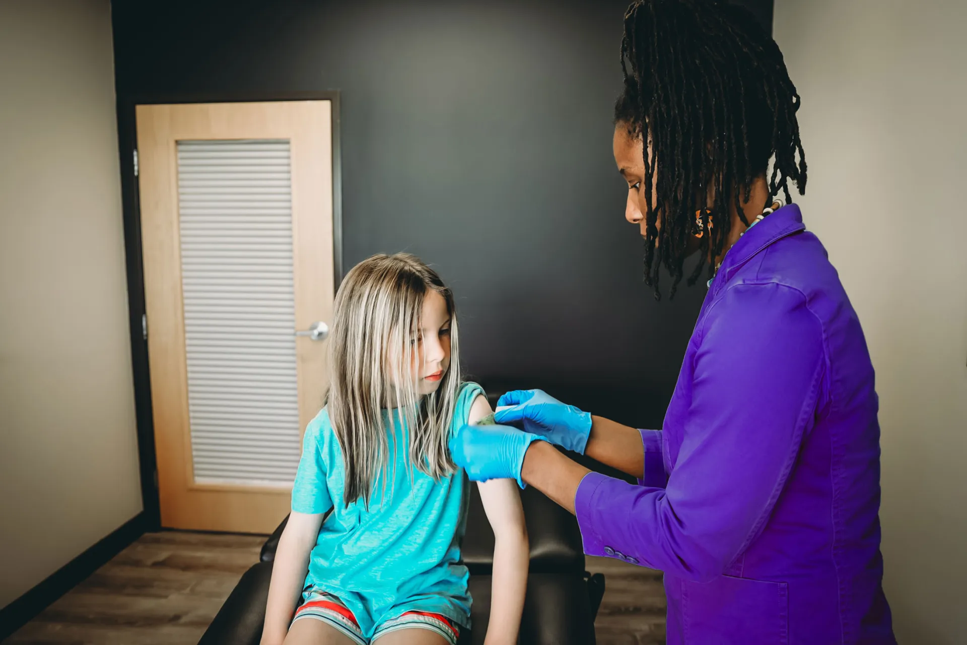 Doctor putting bandaid on patient after getting a vaccine